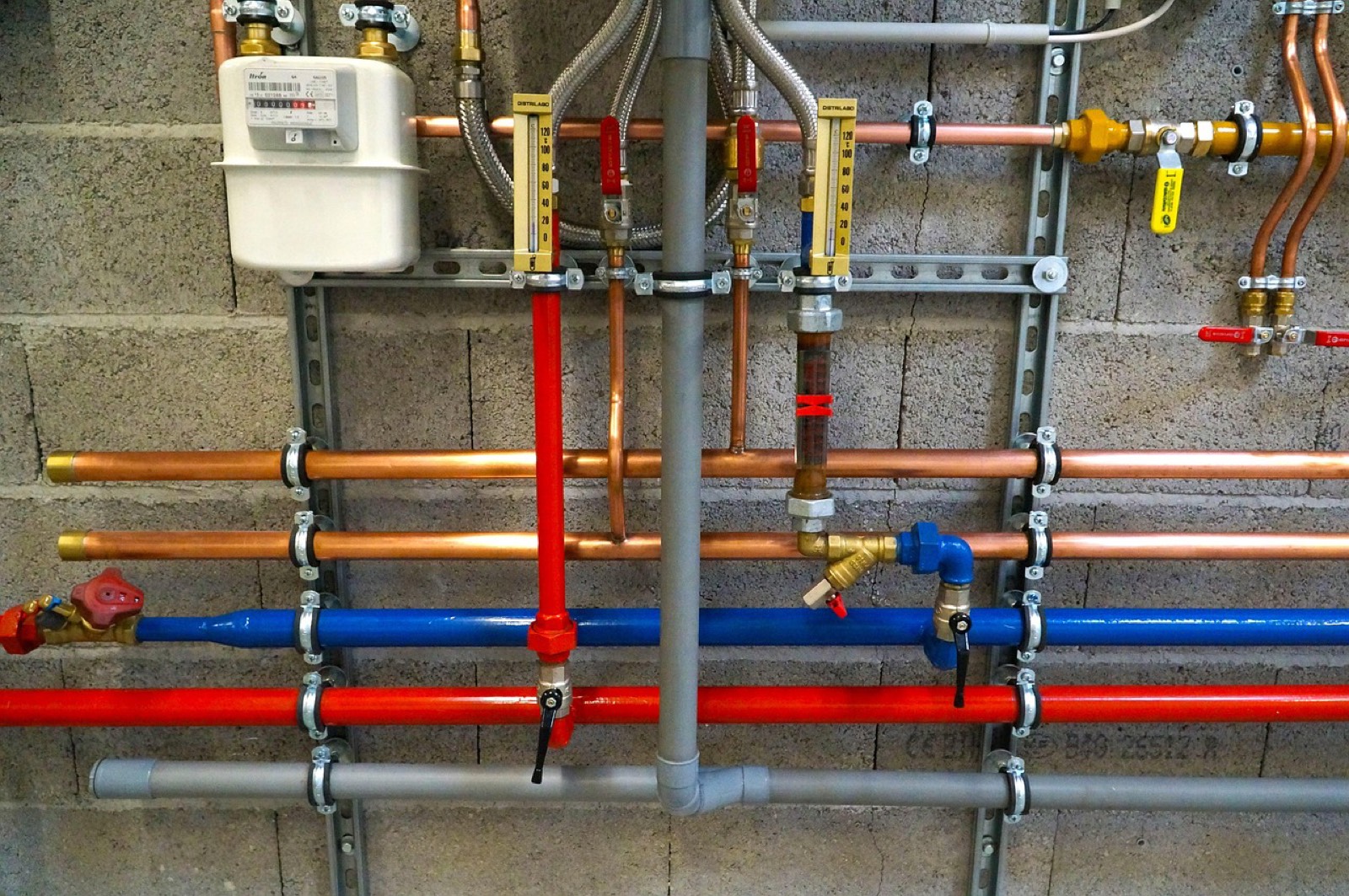 Technicien contrôlant des raccords de tuyauterie sous un évier lors d'un dépannage