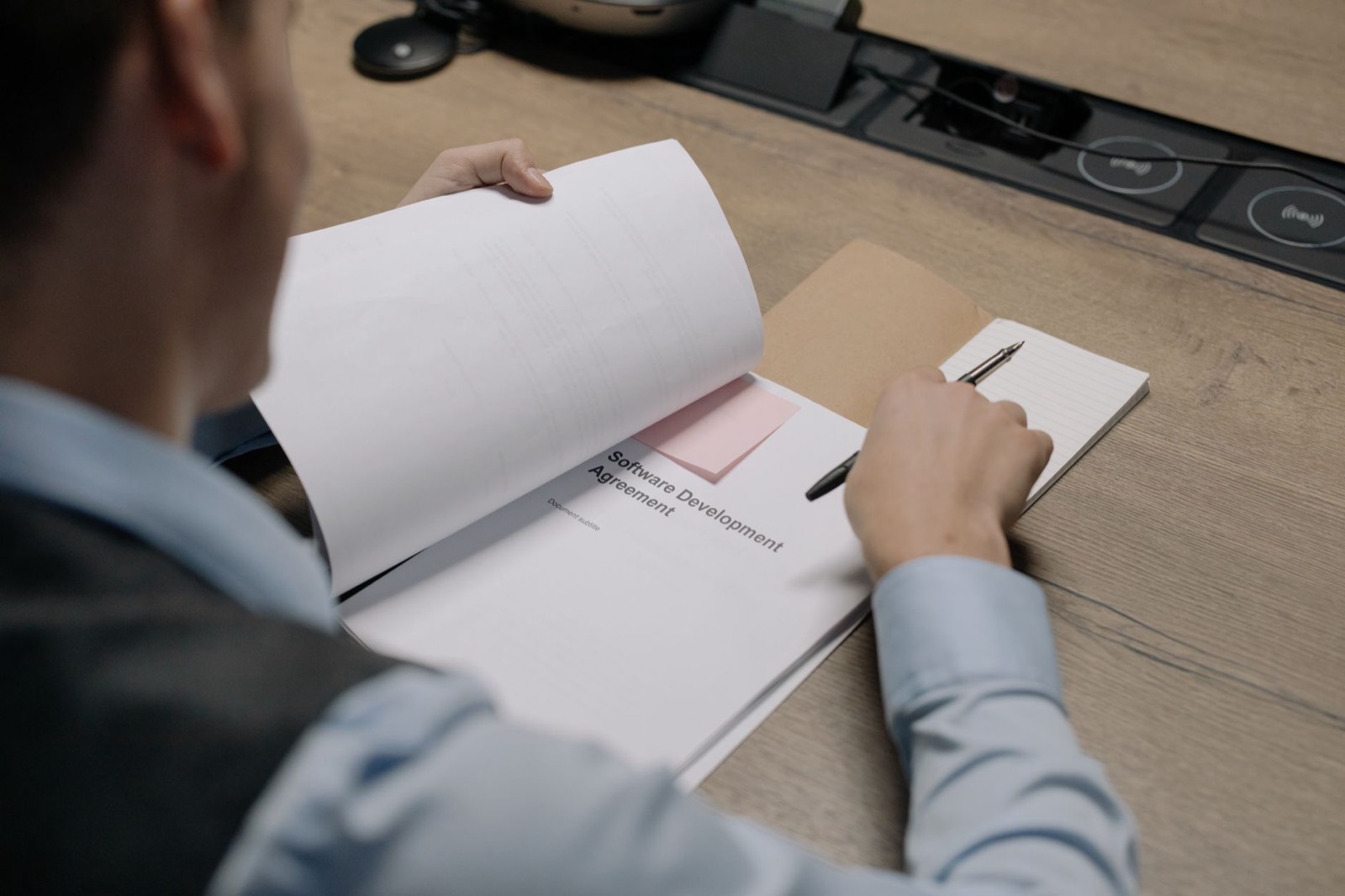 Chef d'entreprise examinant une maquette de site internet et un contrat avant signature