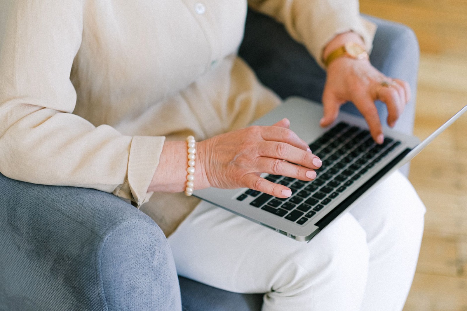 Personne âgée tapant sur un clavier d'ordinateur portable