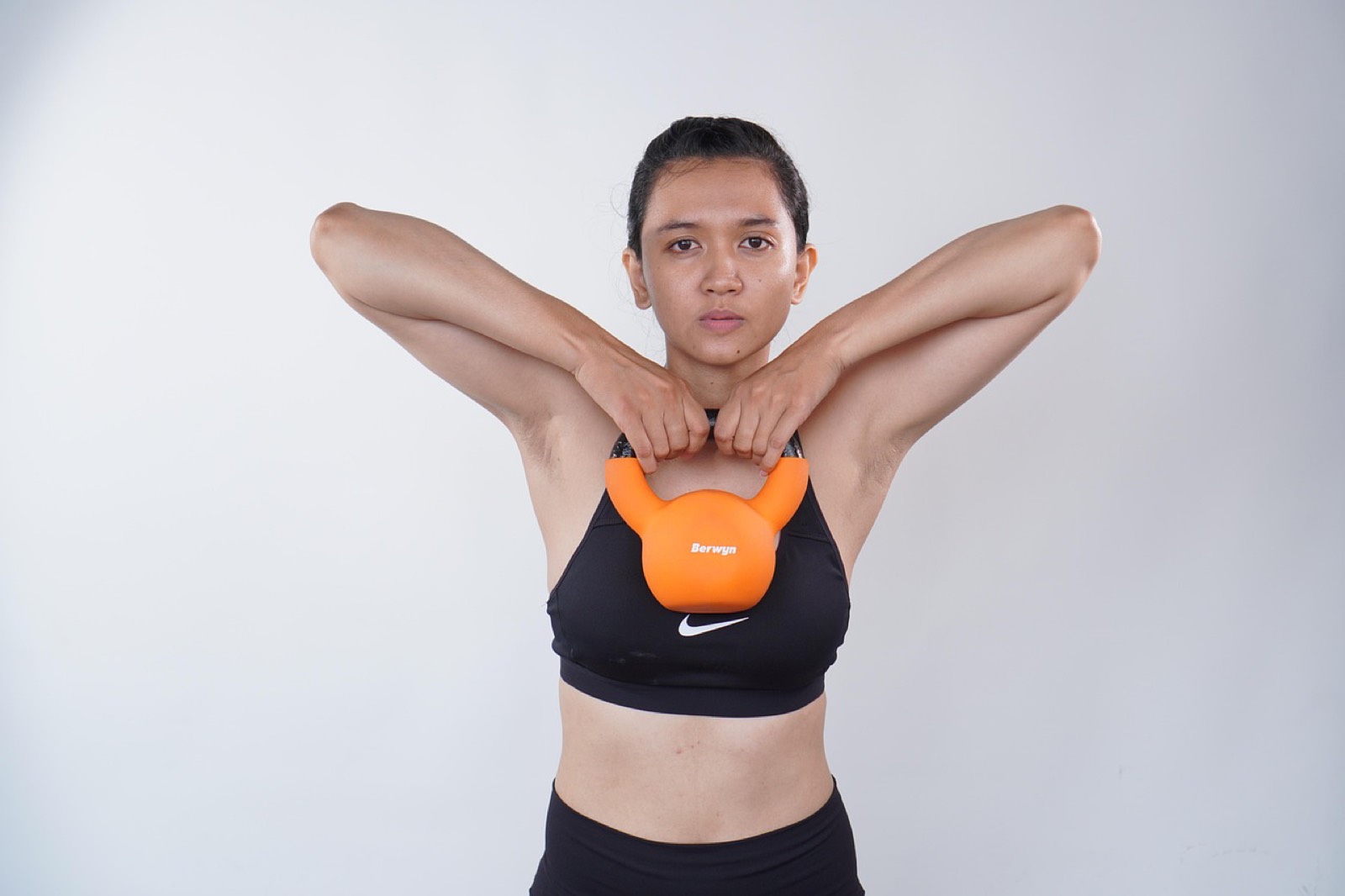 Femme en position de charnière de hanche avec une kettlebell, dos plat, avant le départ du swing