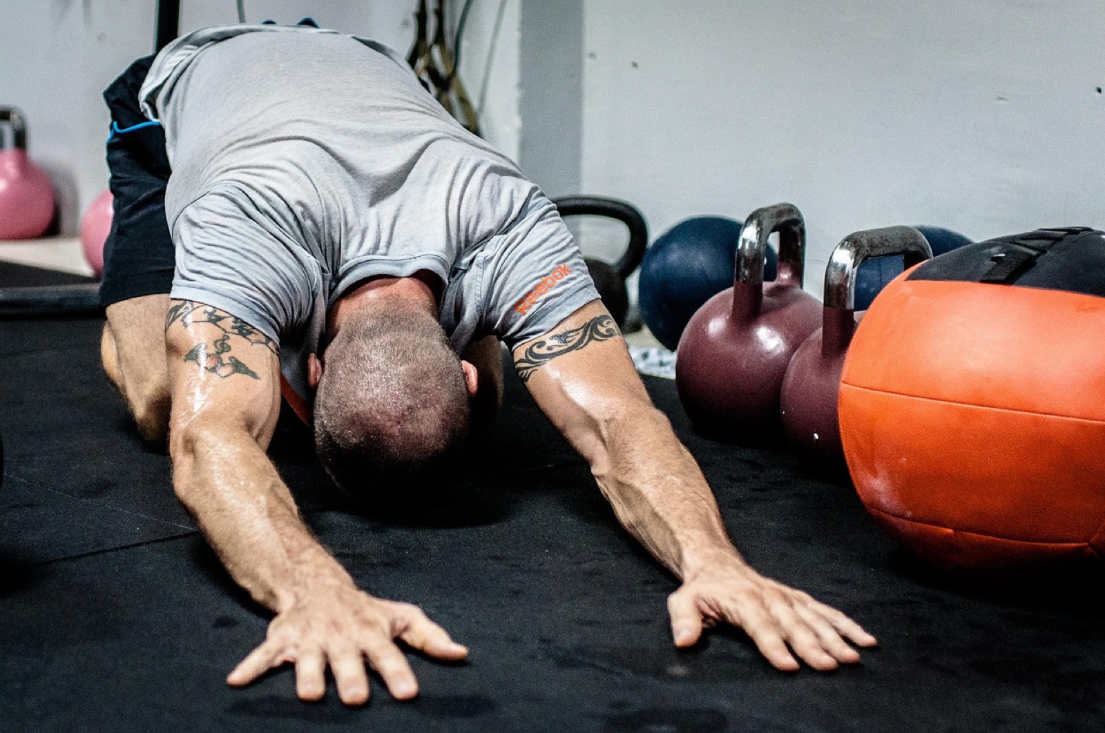 Kettlebell tenue bras tendus au-dessus de la tête dans une salle de sport