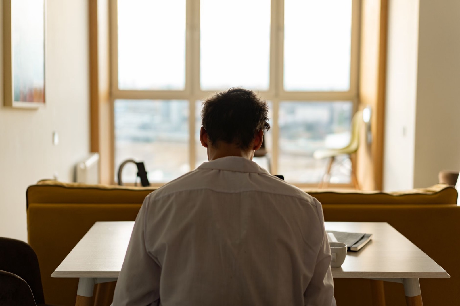 Personne assise à un bureau, dos voûté, illustrant la posture sédentaire responsable des douleurs lombaires