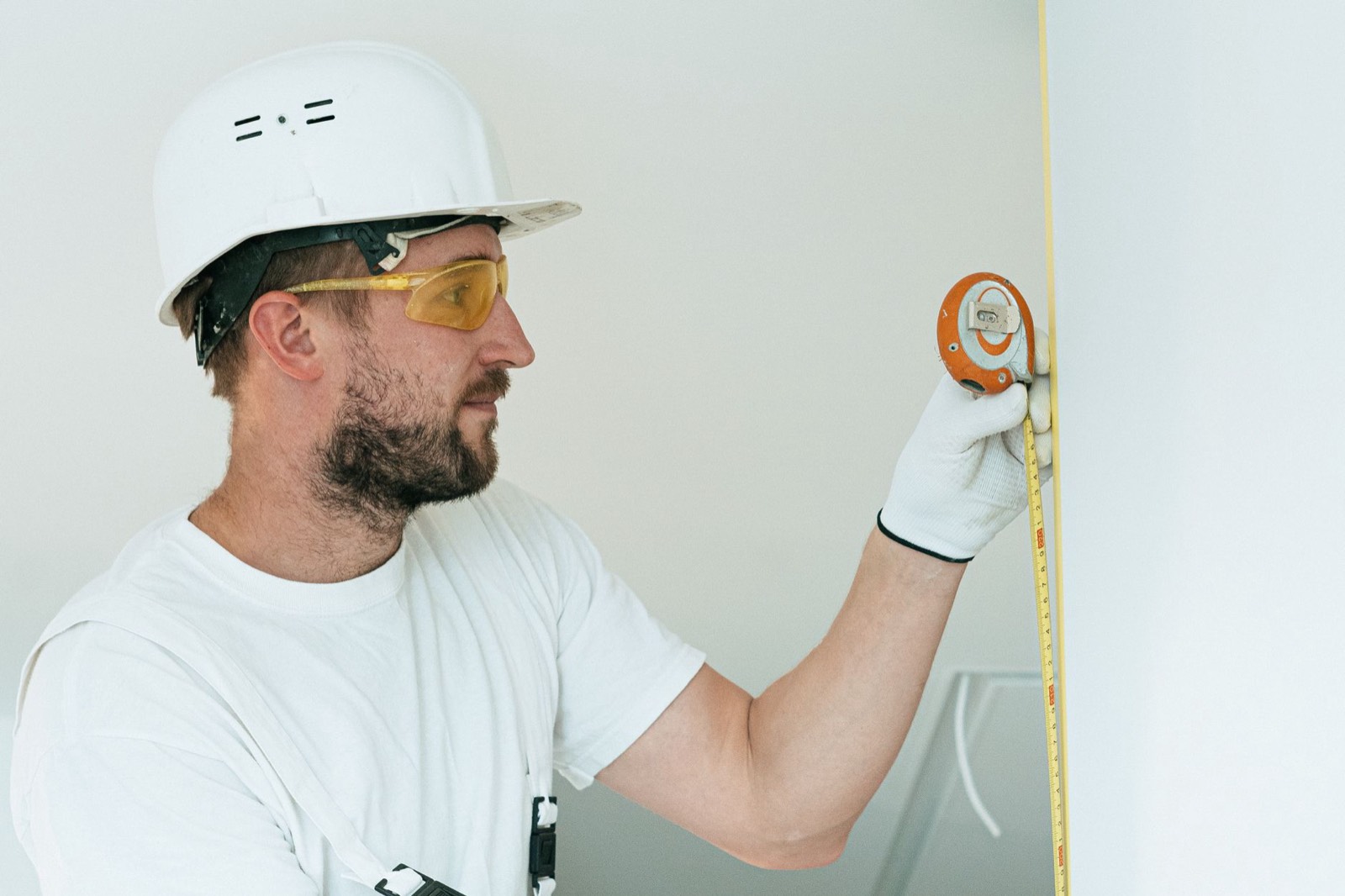 Outil de mesure laser utilisé dans l'angle d'un mur avant travaux