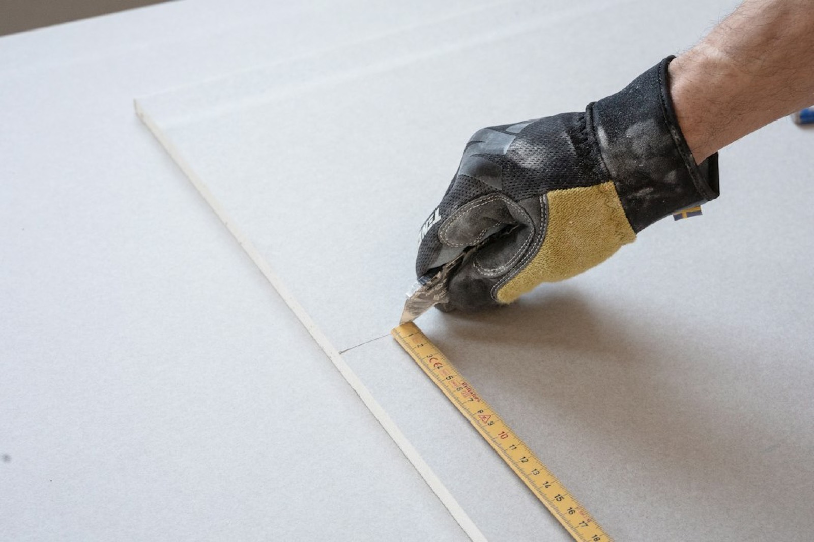 Ouvrier mesurant un mur avant travaux de rénovation
